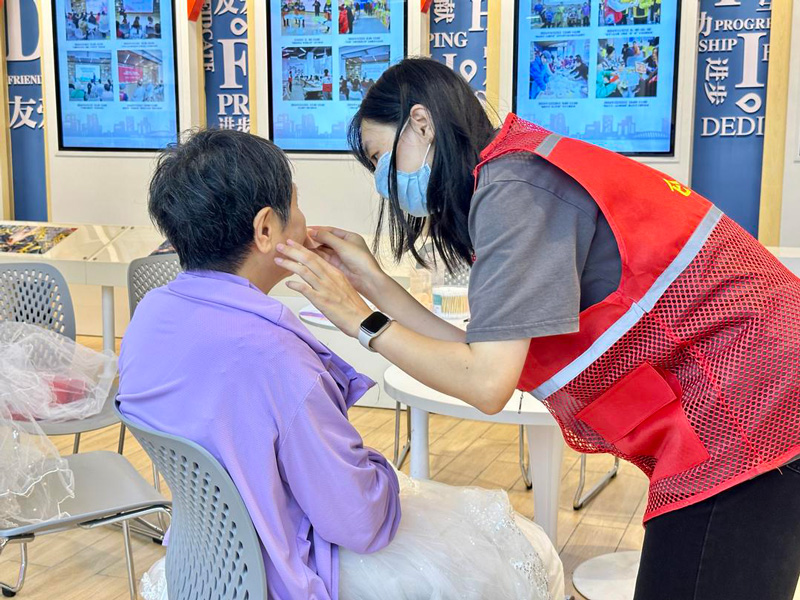 志愿者为老人化妆。刘唯摄