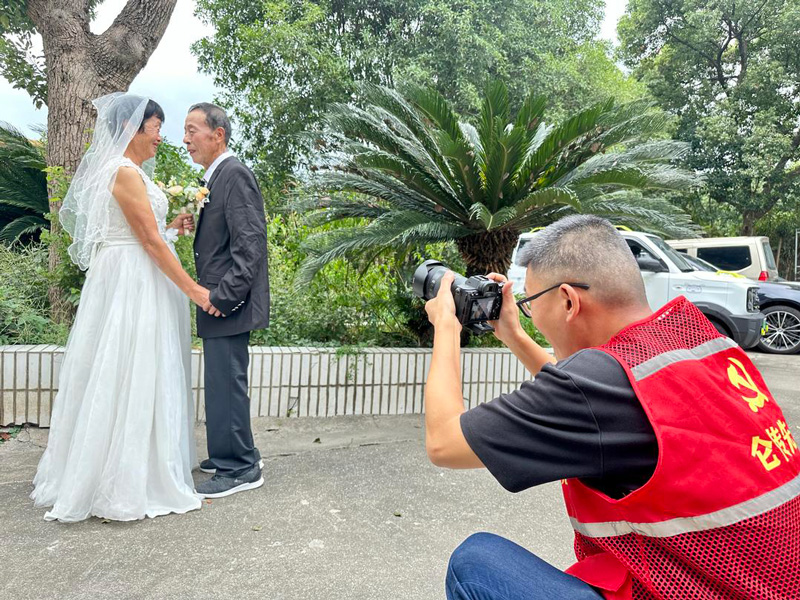 志愿者为金婚老人拍摄。刘唯摄